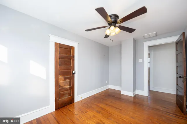 a view of empty room with wooden floor