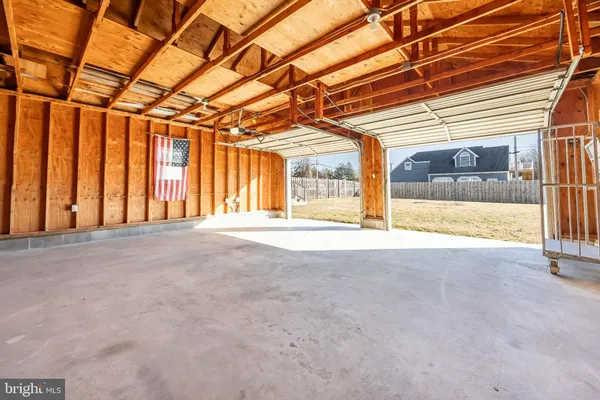 a big house with large trees and wooden fence
