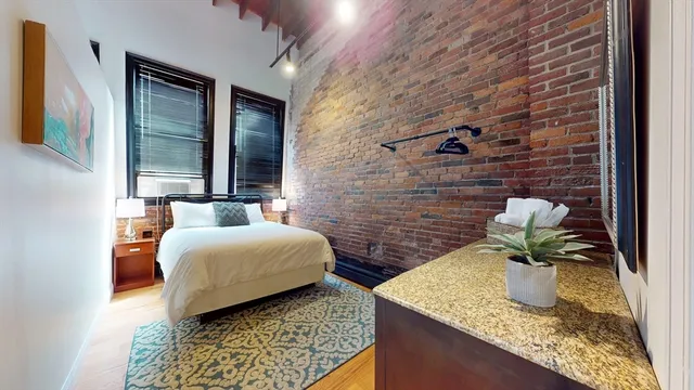 a bedroom with a bed and a potted plant