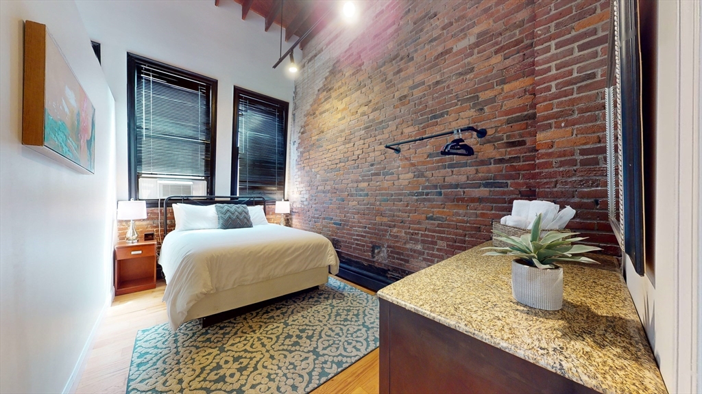 19 Stanhope Street, Unit 3B Boston, MA 02116 - Photo 4 of 5 a bedroom with a bed and a potted plant