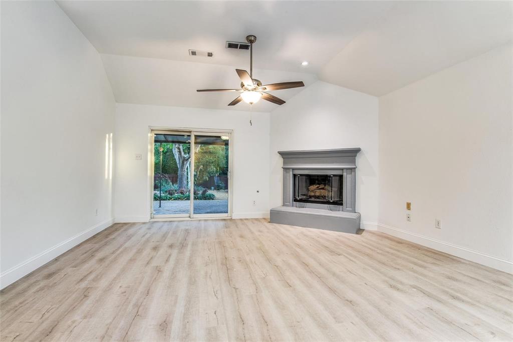 2504 Whetstone Drive Corinth, TX 76210 - Photo 8 of 19 a view of an empty room with a fireplace and a window