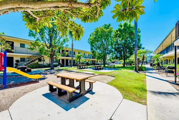 a view of a swimming pool with lounge chair and palm trees