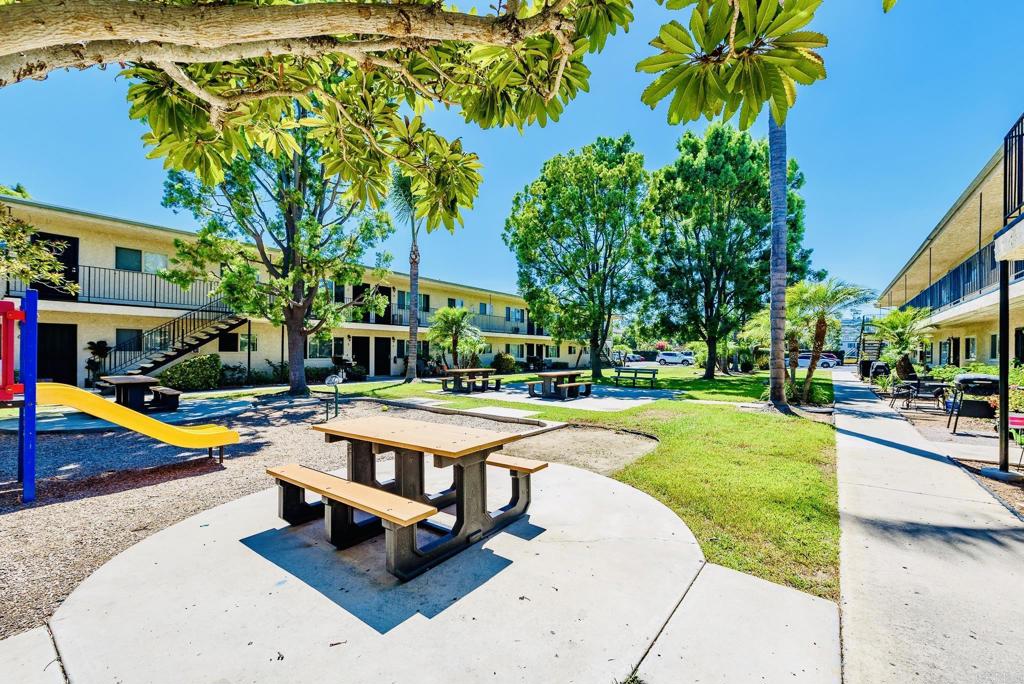 a view of a swimming pool with lounge chair and palm trees