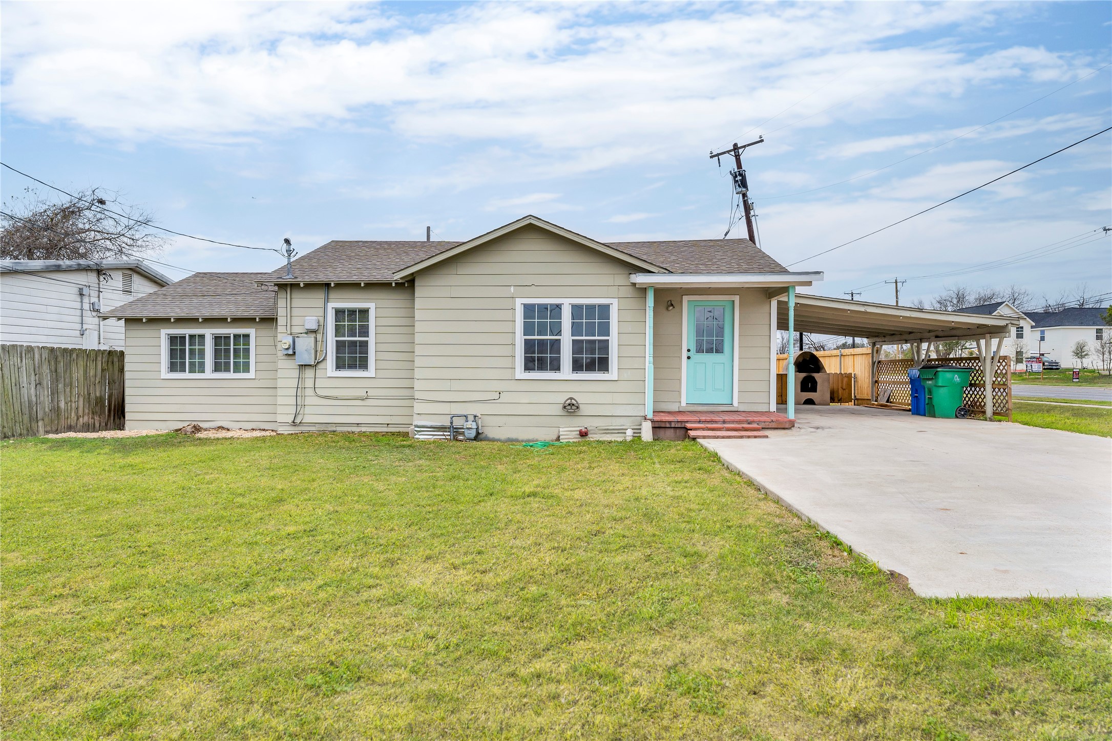 117 Travis Street Taylor, TX 76574 - Photo 2 of 23 a front view of a house with a garden and yard