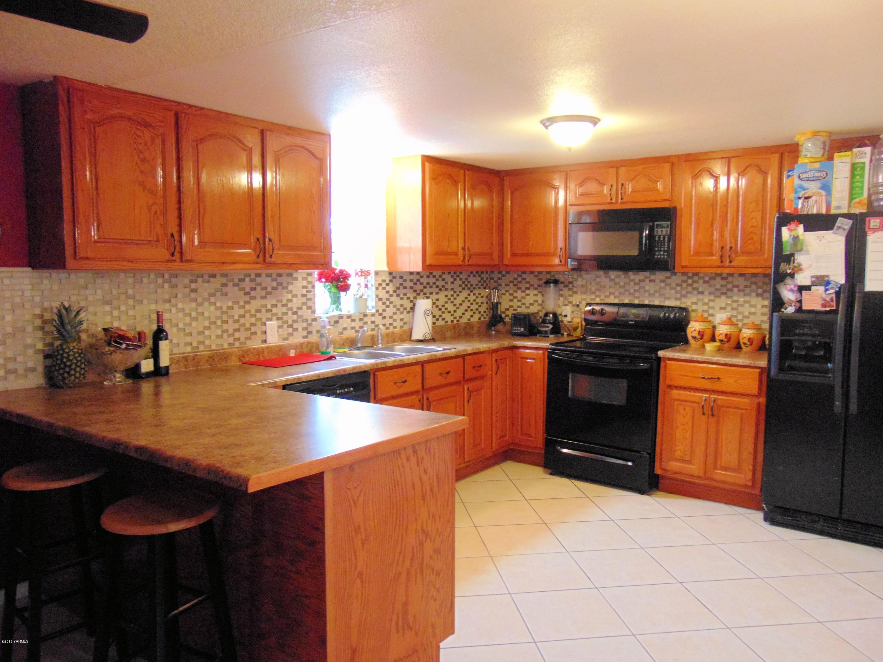 1520 Houghton Road Zillah, WA 98953 - Photo 3 of 15 a kitchen with stainless steel appliances a sink stove and refrigerator