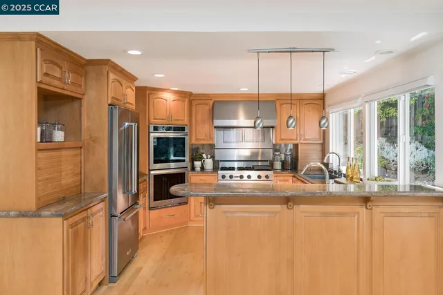 a kitchen with stainless steel appliances a refrigerator and a stove top oven