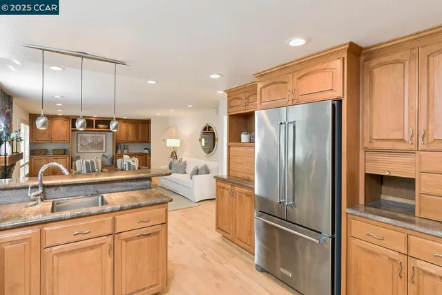 a kitchen with stainless steel appliances granite countertop a refrigerator and a sink