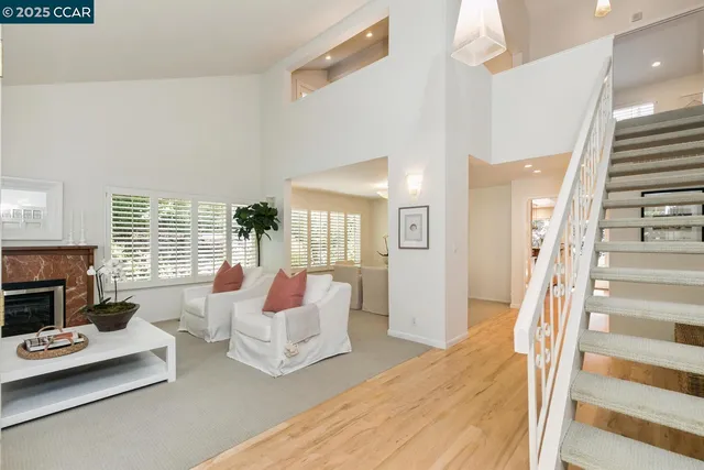 a living room with furniture fireplace and a large window