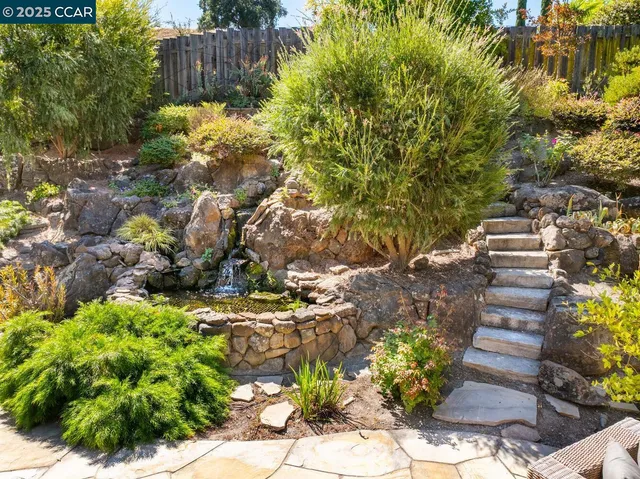 a view of a house with backyard sitting area and garden