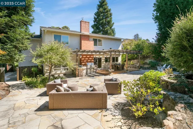 a view of backyard with outdoor seating and trees