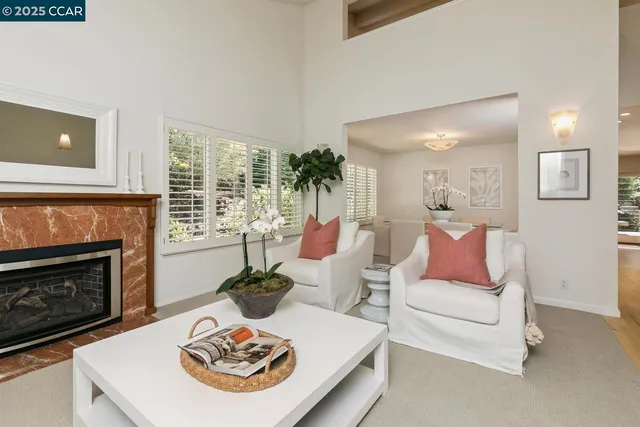 a living room with furniture a fireplace and a large window