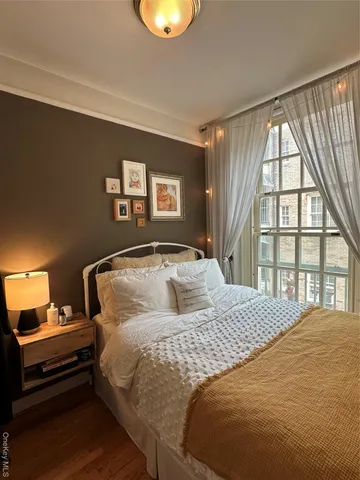 a bedroom with a bed and a large window