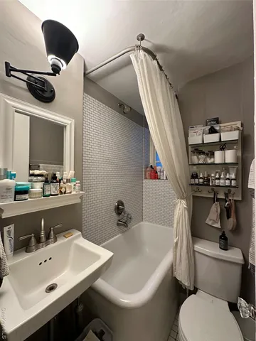 a bathroom with a toilet sink and mirror