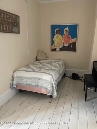 a bedroom with a bed and painting on the wall