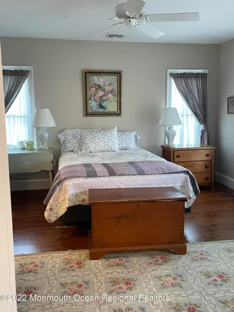 a bedroom with a bed and a dresser next to a window