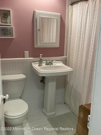 a bathroom with a toilet a sink and mirror