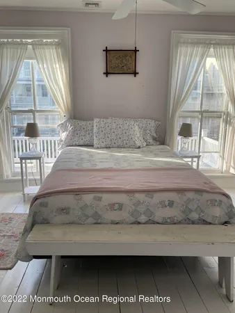 a living room with a balcony a bed and a large window