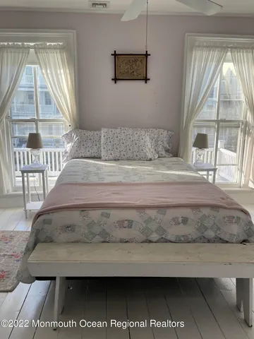 a living room with a balcony a bed and a large window