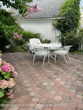 a view of a tables and chairs in back yard of a house