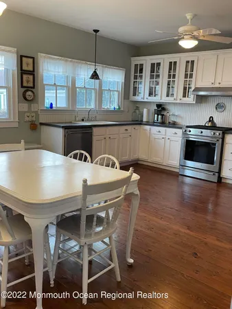 a kitchen with a table chairs microwave and cabinets