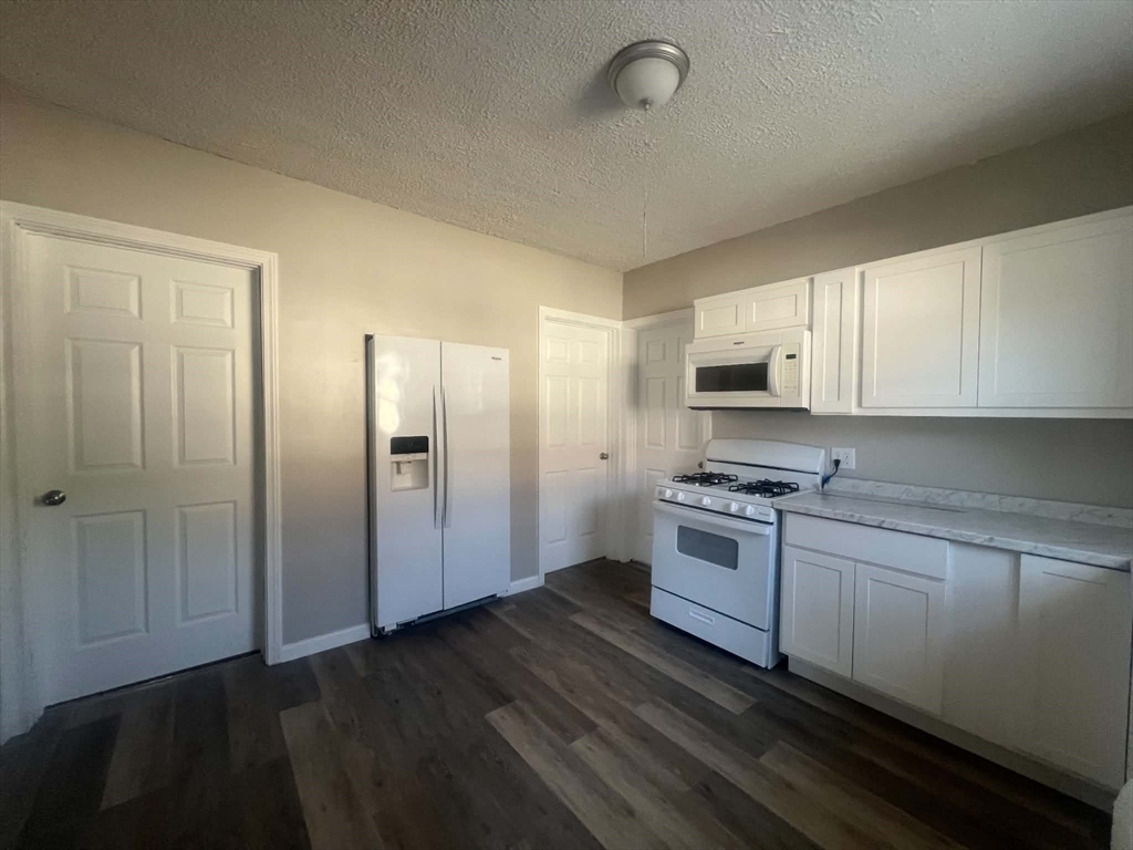 1276 Page Boulevard Springfield, MA 01104 - Photo 2 of 4 a kitchen with stainless steel appliances granite countertop a stove a sink and a refrigerator