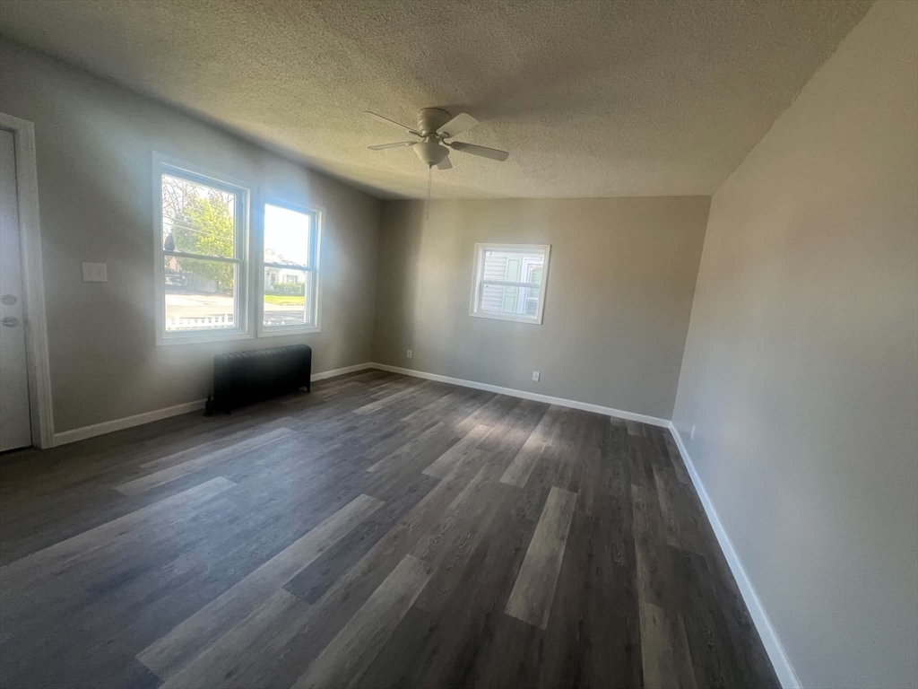 1276 Page Boulevard Springfield, MA 01104 - Photo 3 of 4 a view of an empty room with a window and wooden floor