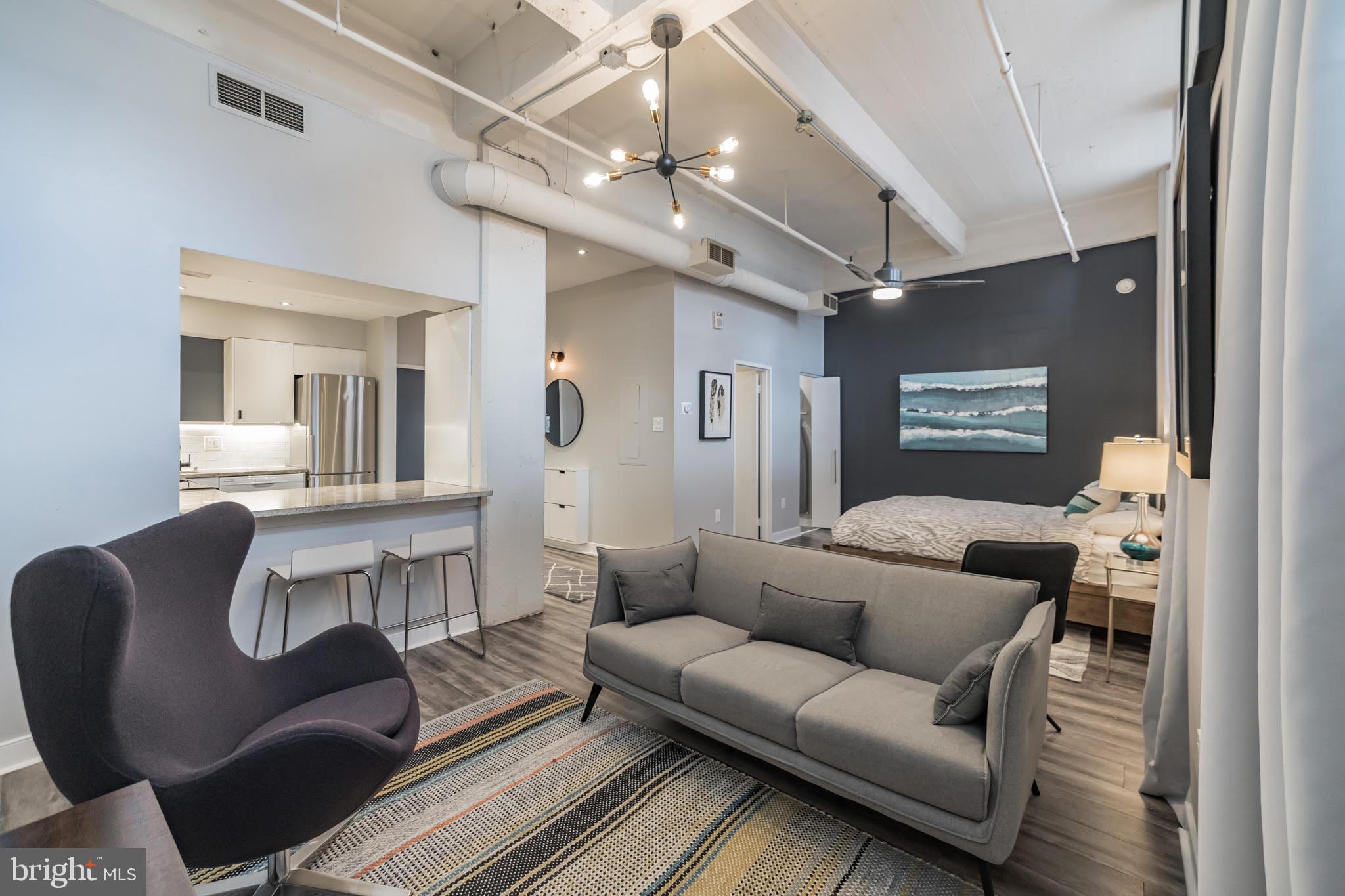 1238 Callowhill Street, Unit 101 Philadelphia, PA 19123 - Photo 2 of 17 a living room with furniture and a chandelier