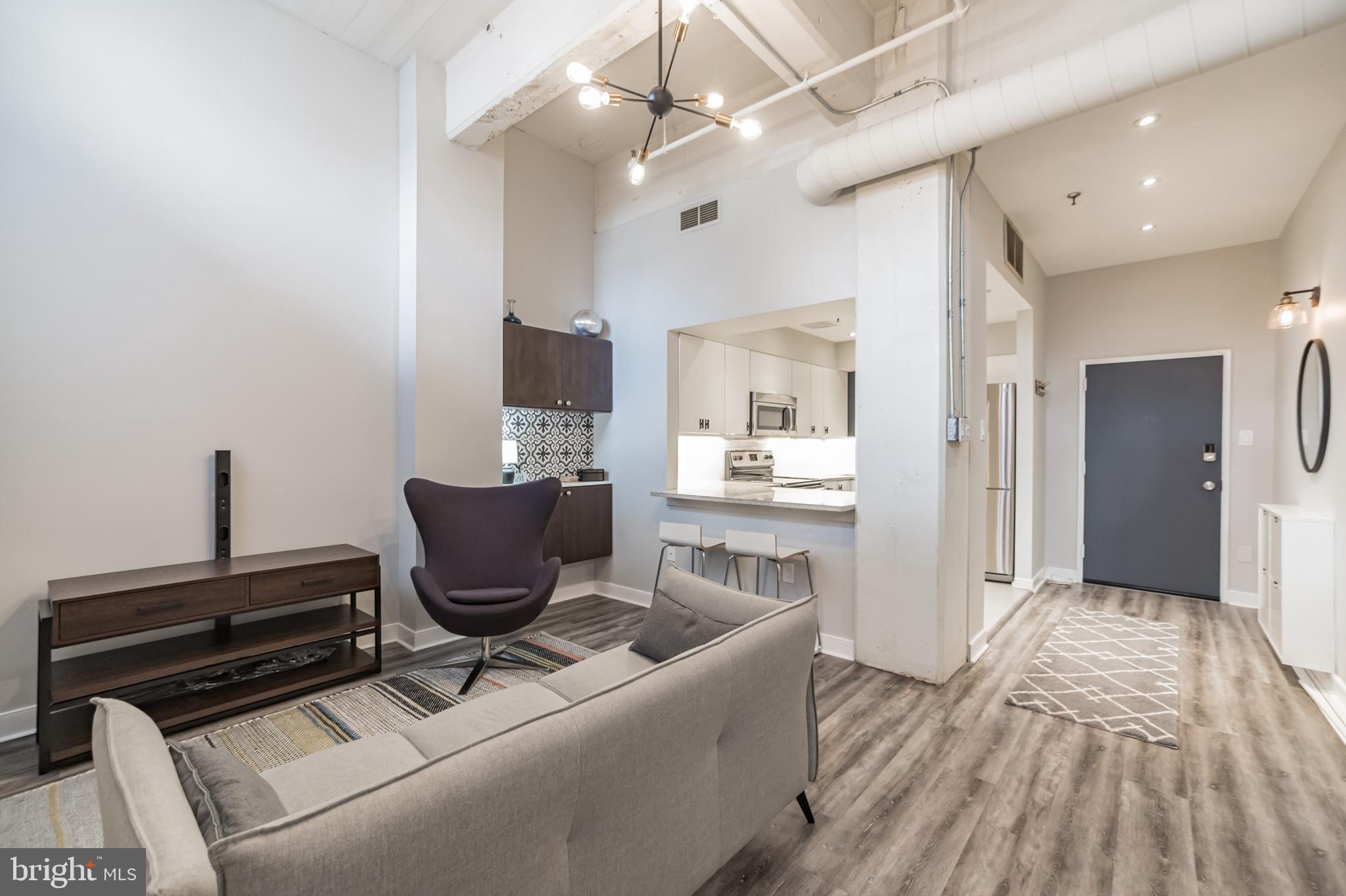 1238 Callowhill Street, Unit 101 Philadelphia, PA 19123 - Photo 5 of 17 a living room with furniture and a flat screen tv