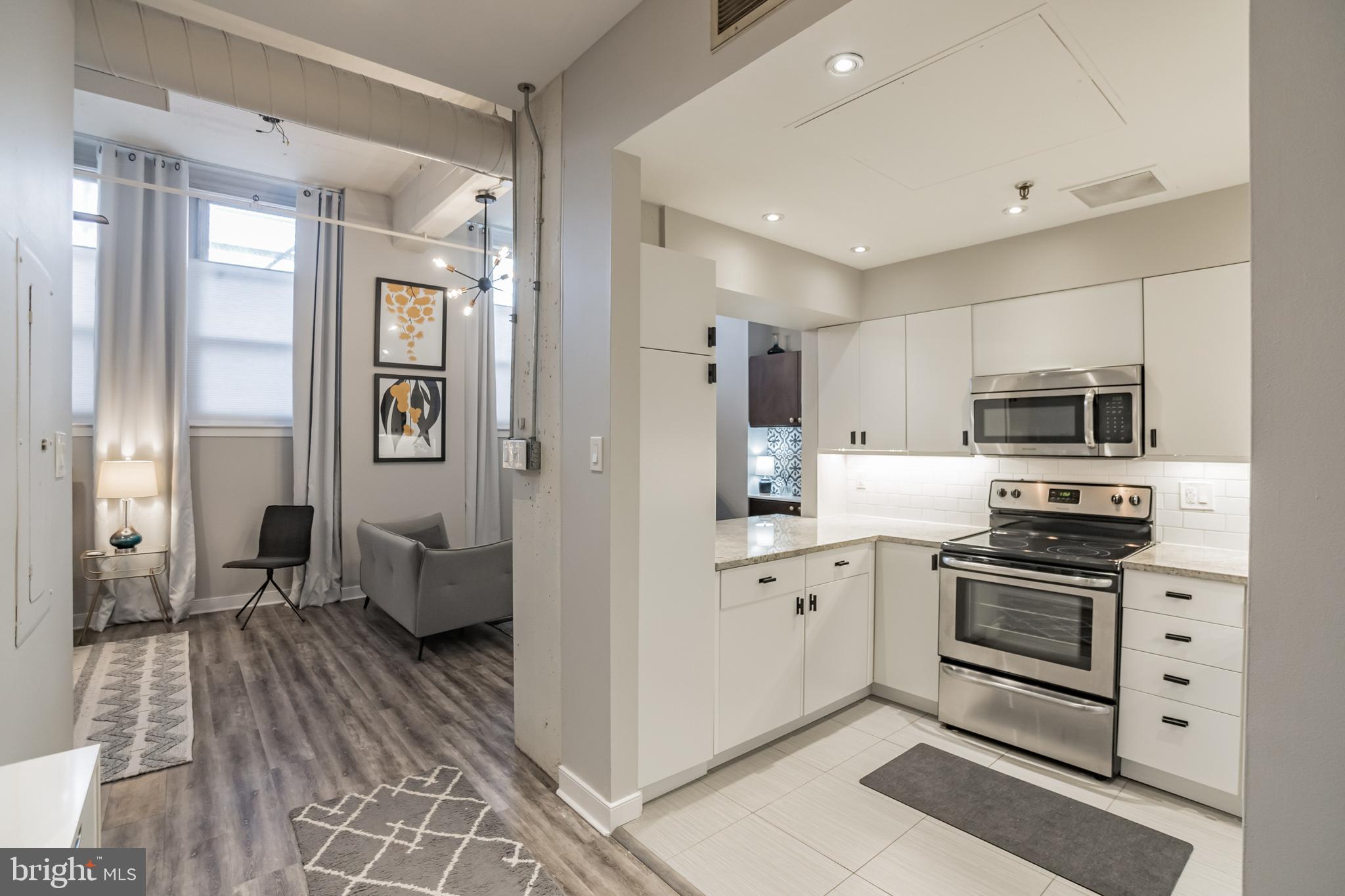 1238 Callowhill Street, Unit 101 Philadelphia, PA 19123 - Photo 7 of 17 a kitchen with stainless steel appliances a stove sink and refrigerator