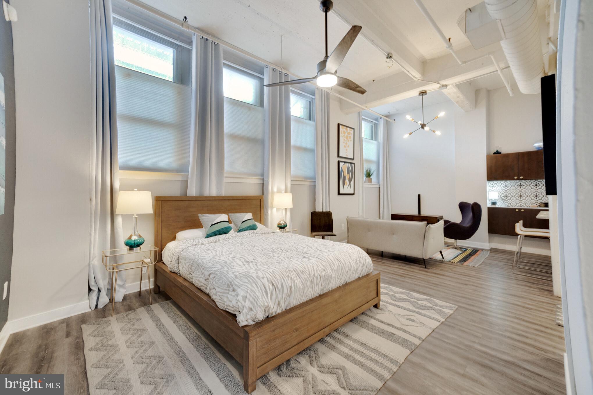 1238 Callowhill Street, Unit 101 Philadelphia, PA 19123 - Photo 9 of 17 a bedroom with a bed wooden floor and ceiling fan