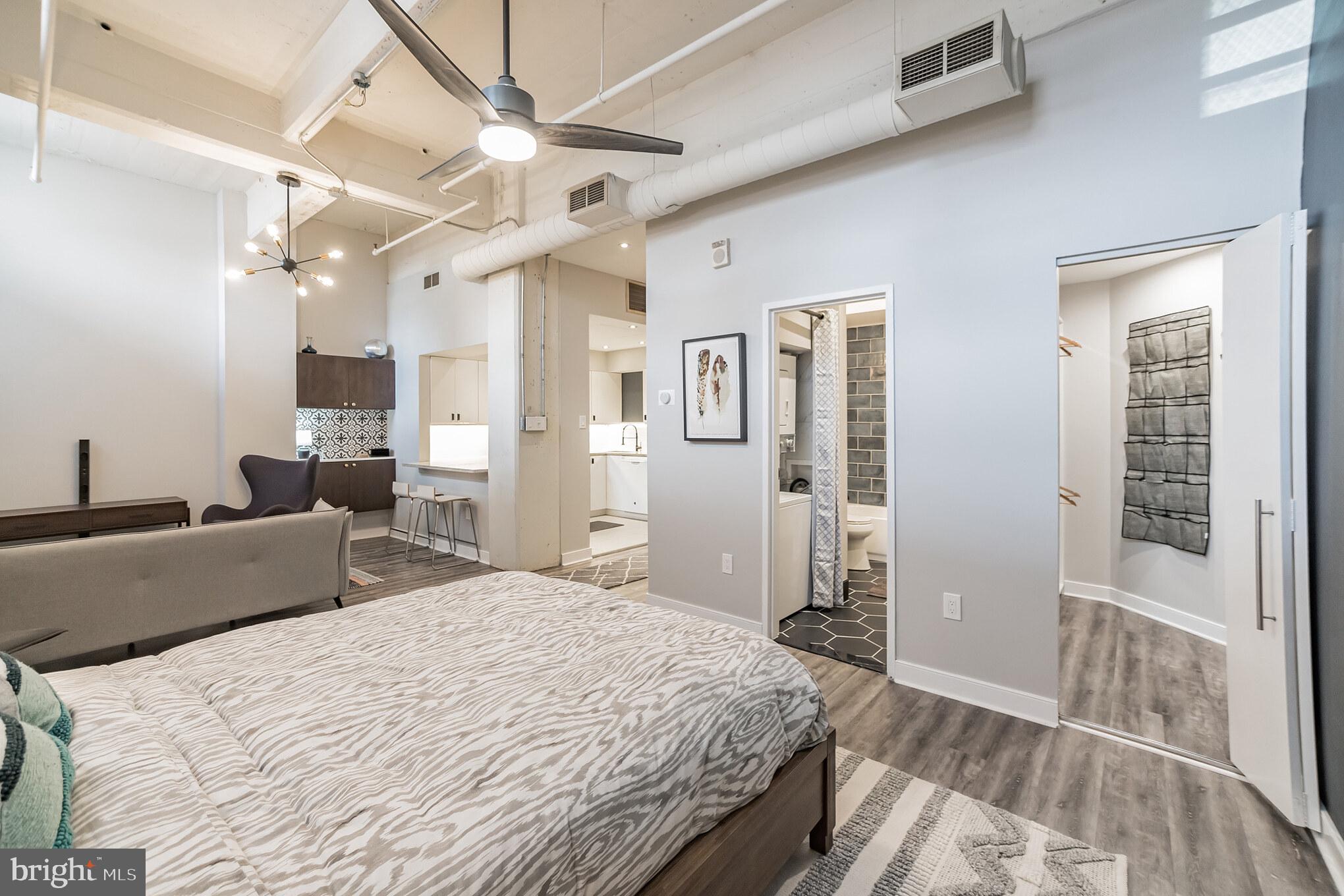 1238 Callowhill Street, Unit 101 Philadelphia, PA 19123 - Photo 10 of 17 a bedroom with a large bed and a chandelier