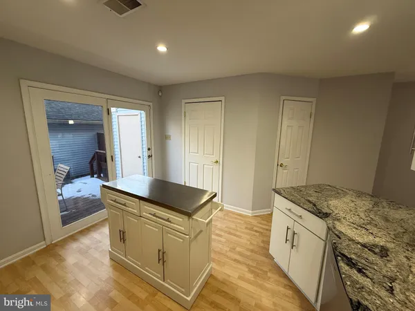 a kitchen with granite countertop a sink and white cabinets