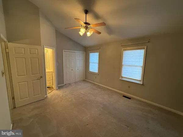 a view of an empty room with a chandelier fan