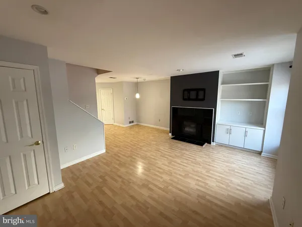 a view of empty room with wooden floor and electronic appliances