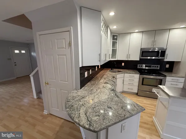 a kitchen with stainless steel appliances granite countertop a sink a stove and a refrigerator