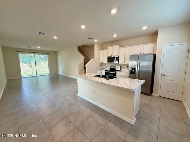 a kitchen with stainless steel appliances a refrigerator sink and microwave