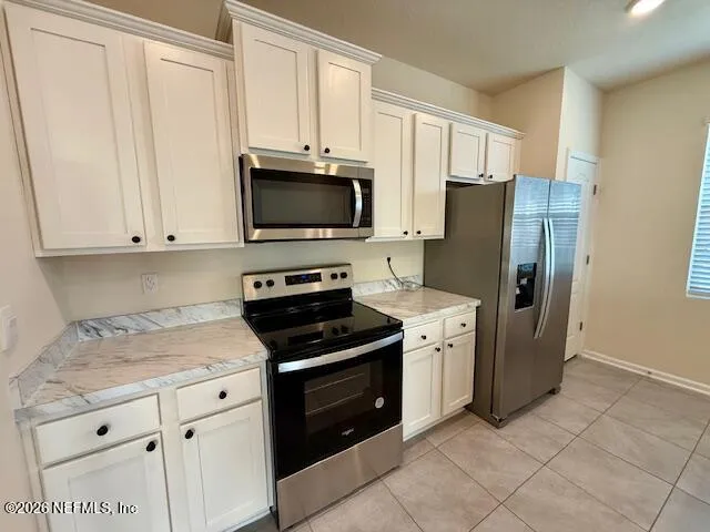 a kitchen with cabinets stainless steel appliances and a counter space