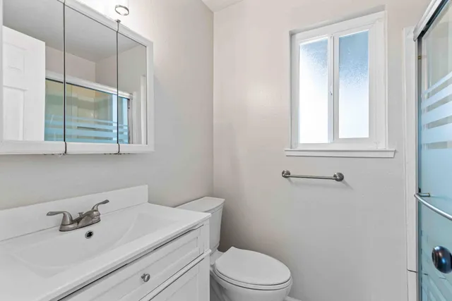 a view of a backyard with wooden fence and large trees