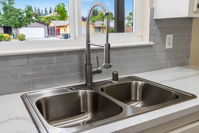 a view of an empty room with wooden floor and window