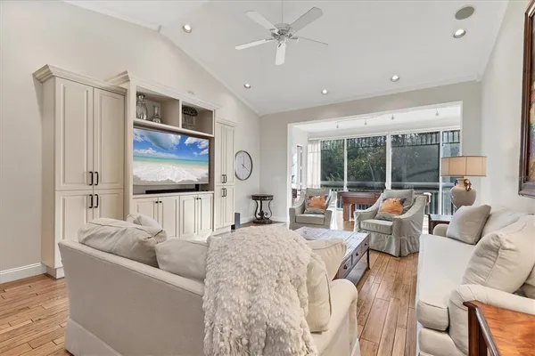 a living room with furniture a large window and a chandelier