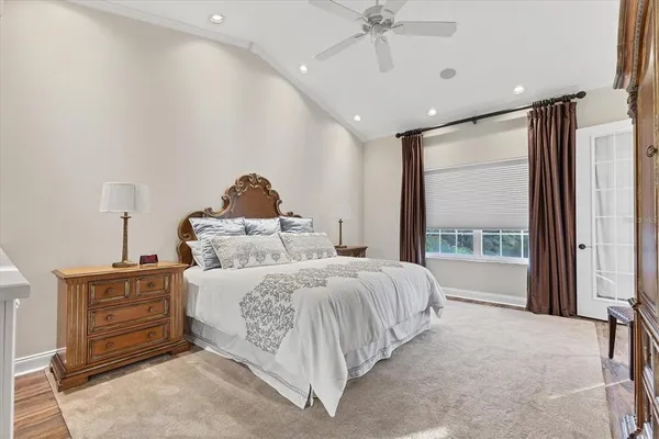 a spacious bedroom with a bed and a chandelier