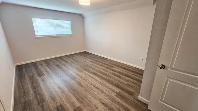 a view of a small space with wooden floor and a window