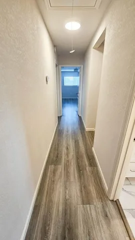 a view of a hallway with wooden floor