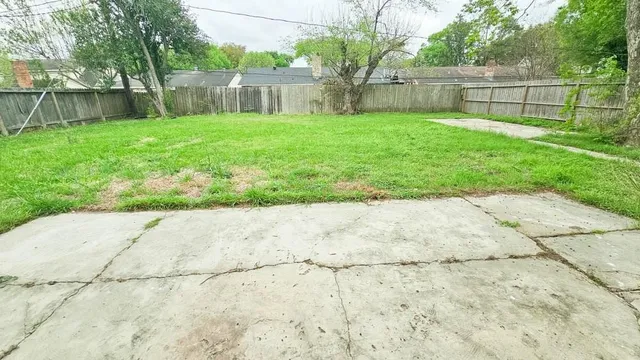 a view of a backyard with wooden fence