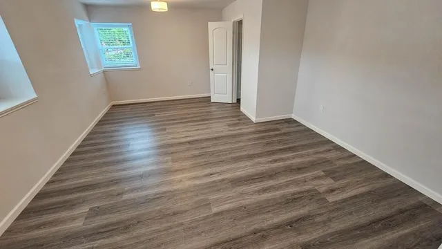 a view of an empty room and wooden floor