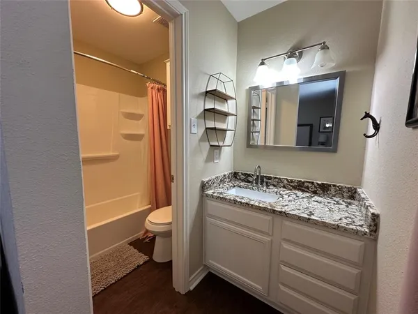a bathroom with a granite countertop sink toilet and shower