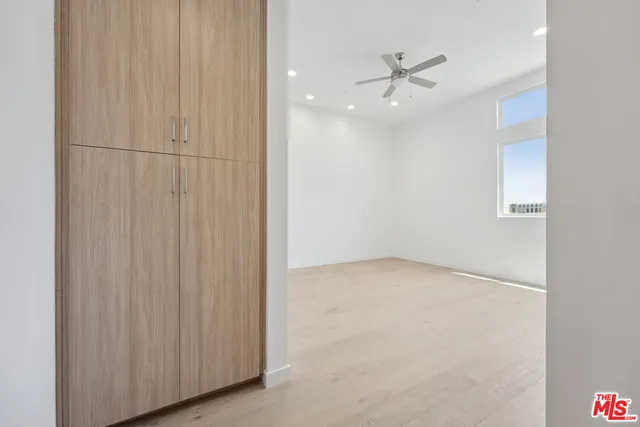 an empty room with a ceiling fan and a window