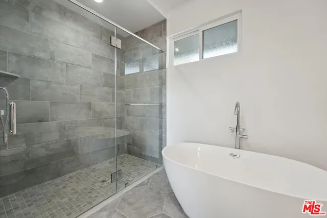 a white bath tub sitting next to a shower