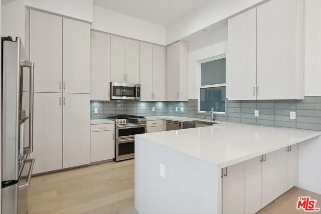 a kitchen with stainless steel appliances white cabinets and a refrigerator
