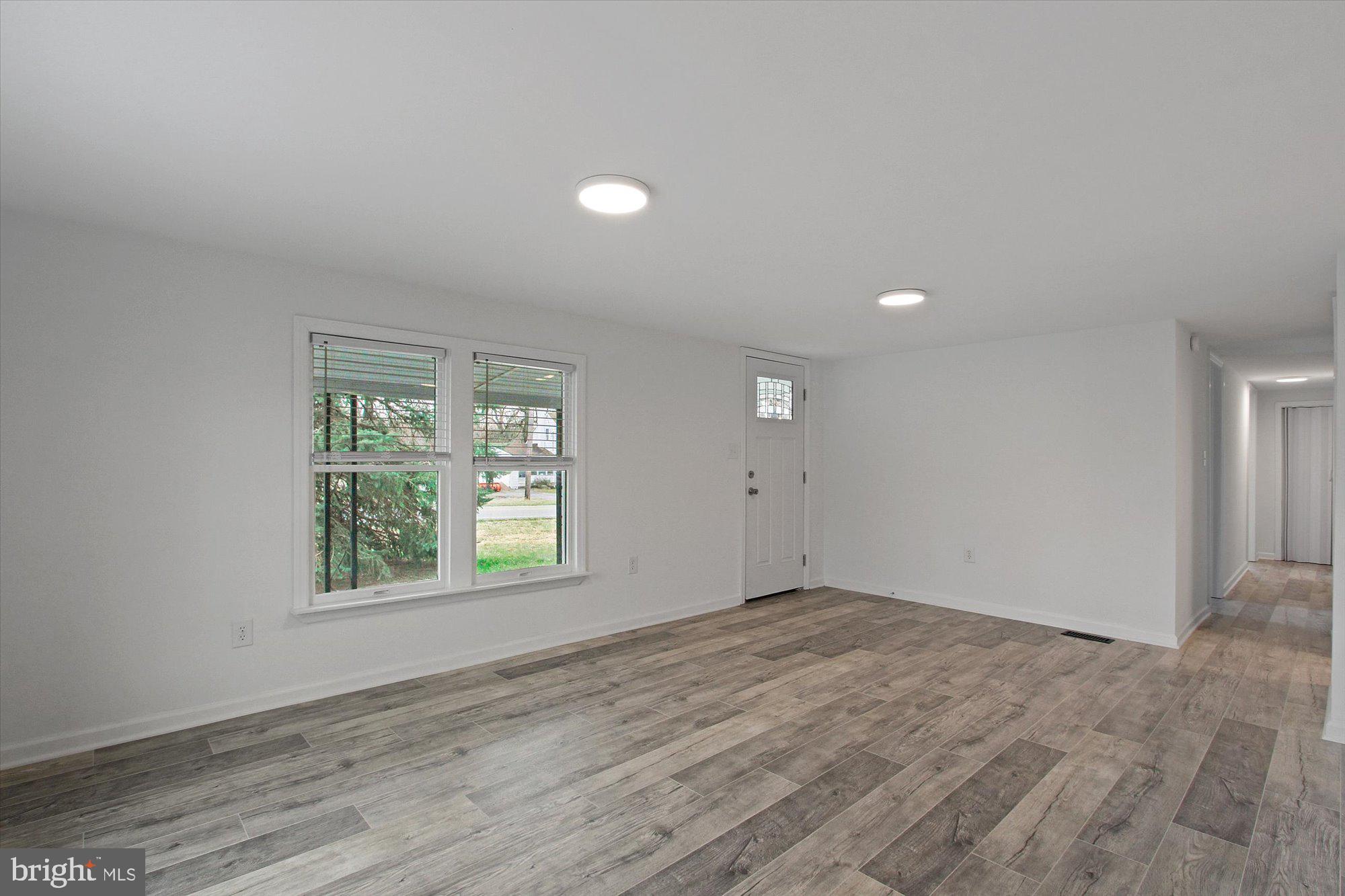 534 Hunterstown Road Gettysburg, PA 17325 - Photo 5 of 18 an empty room with wooden floor and windows